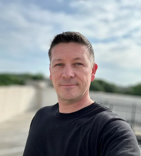 Travis Murphy, the founder of The Invest Nest, photographed outdoors on a clear day